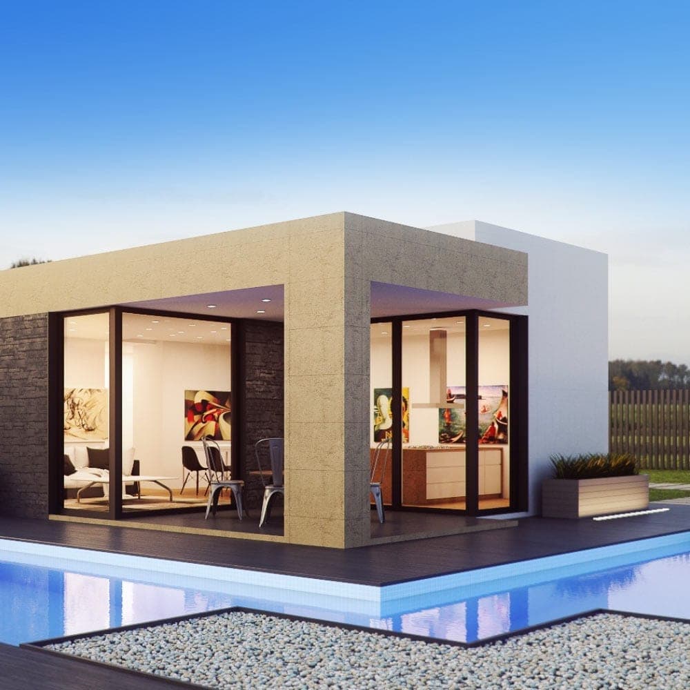 Modern house with large glass windows and a pool in the foreground under a clear blue sky.